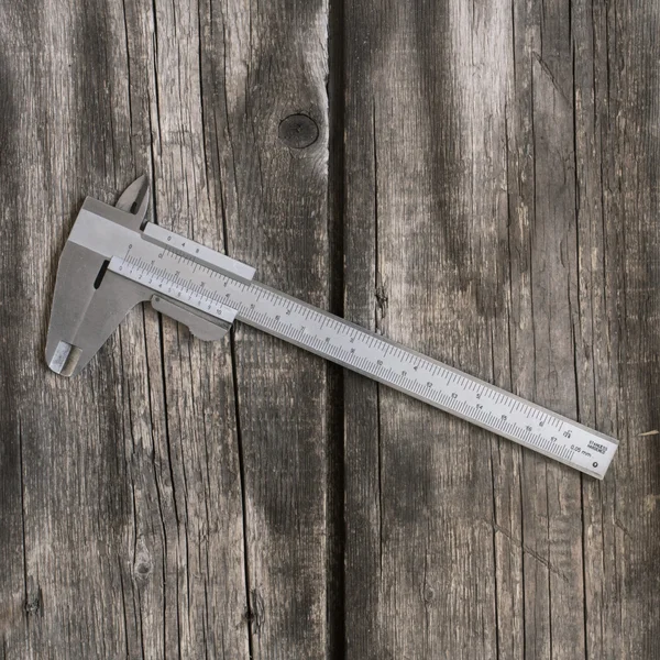 Steel calliper on wood — Stock Photo, Image