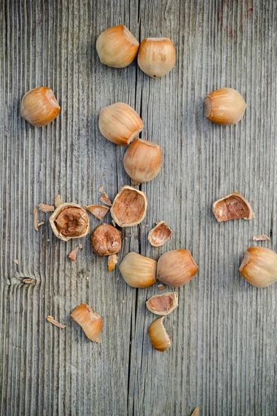 Cracked nuts on old wooden background — Stock fotografie