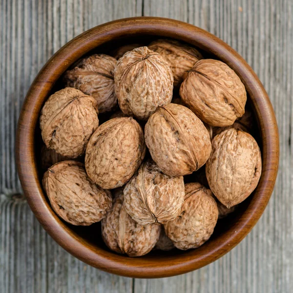 Walnuts in a bowl - rustic wooden table — Stock fotografie