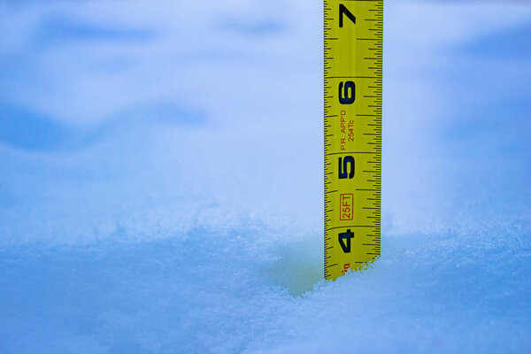 Измерение глубины снега с помощью жёлтой линейки 4 фута