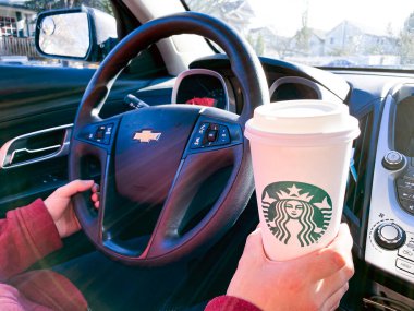 Calgary, Alberta. Kanada mı? 27 Ekim 2020. Araba kullanırken elinde Starbucks kahvesi tutan biri..