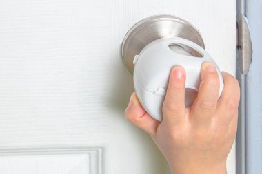 Kapıyı açmaya çalışan bir çocuk ve kapı tokmağının üzerindeki kapı tokmağı..