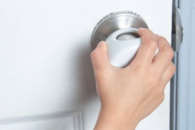 Kapıyı açmaya çalışan bir çocuk ve kapı tokmağının üzerindeki kapı tokmağı..