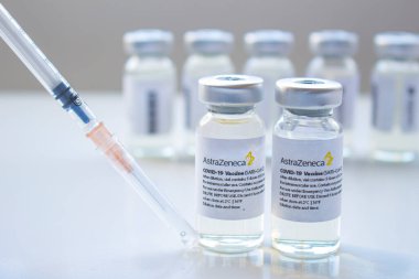 Calgary, Alberta, Kanada. Ocak 03, 2021. AstraZeneca Covid-19 aşılarının seçici odak noktası temiz bir arkaplanda şırınga ile şişeleri şişeler.