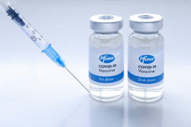 Calgary, Alberta, Kanada. 31 Aralık 2020. Pfizer Covid-19 aşıları, temiz bir arkaplanda şırıngayla şişeleri şişeler..