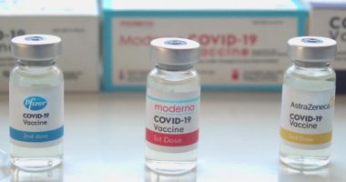 Calgary, Alberta, Kanada. 15 Ocak 2021. Pfizer, Moderna ve AstraZeneca Covid-19 aşı şişeleri, kutular ve enjeksiyonlar veya şırıngalar yakın çekim ve dolly.