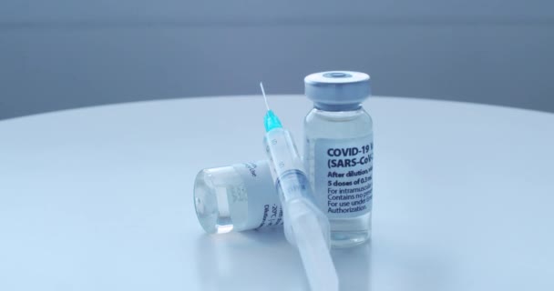 一个旋转相机在白色桌子上旋转着Covid 19疫苗 预防结肠病毒 — 图库视频影像