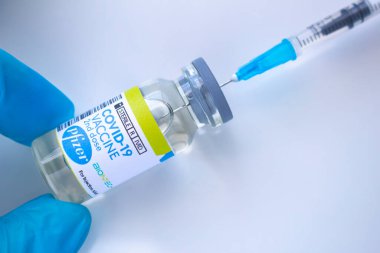 Calgary, Alberta. Kanada mı? 20 Ocak 2021. Pfizer aşısı olan bir sağlık çalışanı ve beyaz arka planda bir şırınga.