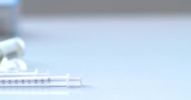 Covid-19 Aşıları 'nın Dolly' si boş bir masada şırıngalarla şişeleri şişeler..