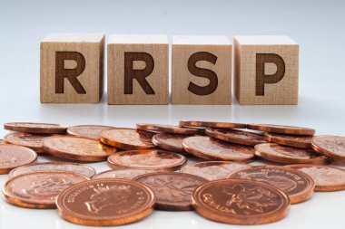 Tahta bloklarda RRSP harfleri ve temiz bir arkaplan üzerinde bozuk paralar
