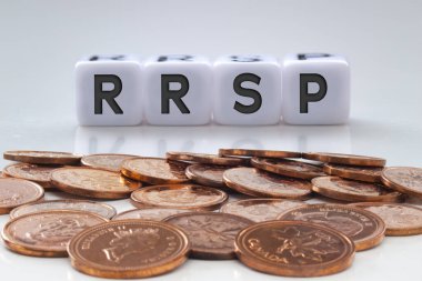 Beyaz bloklar üzerinde RRSP harfleri ve temiz bir arkaplan üzerinde bozuk paralar