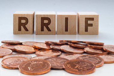 Tahta bloklarda RRIF harfleri ve temiz bir arkaplan üzerinde bozuk paralar.