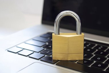 Bilgisayar klavyesinin üstünde bir kilit. Kavram: siber güvenlik, bilgisayar sistemlerinin korunması ve ağların bilgi ifşasından korunması.