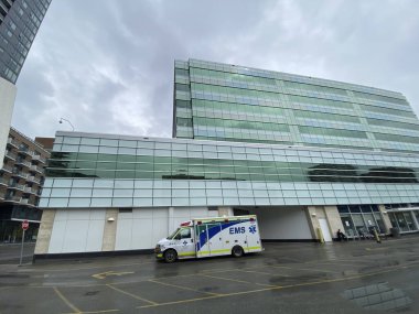 Calgary, Alberta, Kanada. 25 Mayıs 2021 'de Sheldon M. Chumir Sağlık Merkezi Acil Durum Alberta Sağlık Servisi' nde bir ambulans ana binanın görüş alanından ayrıldı..
