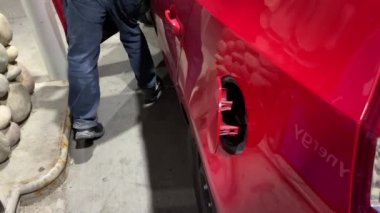 Calgary, AB, Kanada. Sep 22, 2021. Benzin deposunun kapağını açan kişi gaz başlığına bakıyor..