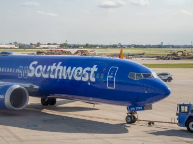 Chicago, Illinois, ABD. 15 Ekim 2025. Güneybatı Havayolları 'na ait mavi üniformalı bir uçak pist boyunca çekiliyor ve uygun fiyatlı yerli hava taşımacılığı ve havaalanı aktivitesini simgeliyor..