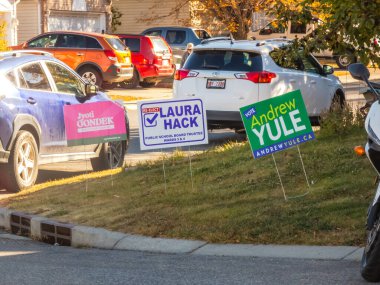 Calgary, Alberta, Kanada. 16 Ekim 2025. JyotiGondek, Laura Hack ve Andrew Yule için siyasi kampanya tabelaları arkalarında arabaların park ettiği bir konutta sergileniyor..