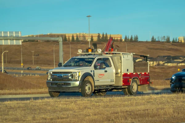 Calgary, Alberta, Kanada. 1 Kasım 2025. EnMAX markalı araç gereç ve ekipmanla mavi gökyüzünün altında açık bir banliyö yolunda ilerliyor