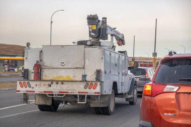 Calgary, Alberta, Kanada. 12 Kasım 2025. Çok şeritli bir yolda monte edilmiş bir yük kamyonu, plakası görünür, arka planda trafik ve benzin istasyonu.