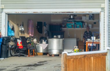 Calgary, Alberta, Kanada. 27 Kasım 2025. Açık Konut Garajında Duran Kadın Depo ve Geçici Mutfak olarak Kullanılıyor.