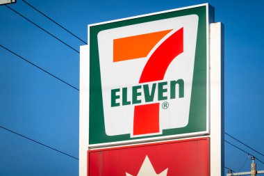 Calgary, Alberta, Kanada. 22 Ocak 2026. Benzin istasyonunda açık mavi gökyüzüne karşı bir 7-Eleven market tabelası..