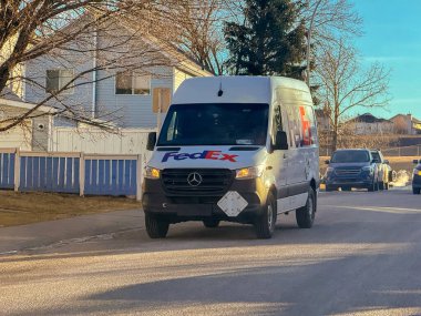 Calgary, Alberta, Kanada. 22 Ocak 2026. FedEx dağıtım minibüsü kış günü meskun mahallelerden geçiyor.