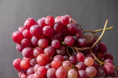 Yakın plan, siyah arka planda izole edilmiş düşük ışıkta koyu üzüm demeti..