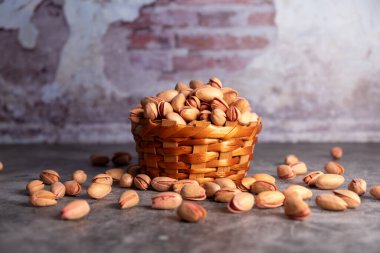 Fotokopi alanı olan küçük sepetli kurumuş fıstıklar. Sağlıklı için tahıl. Kızarmış tuzlu şam fıstığı