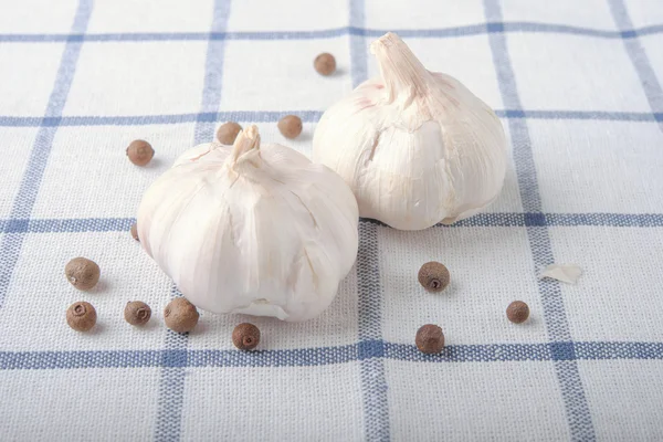 garlic with black bell pepper on squared print cloth table