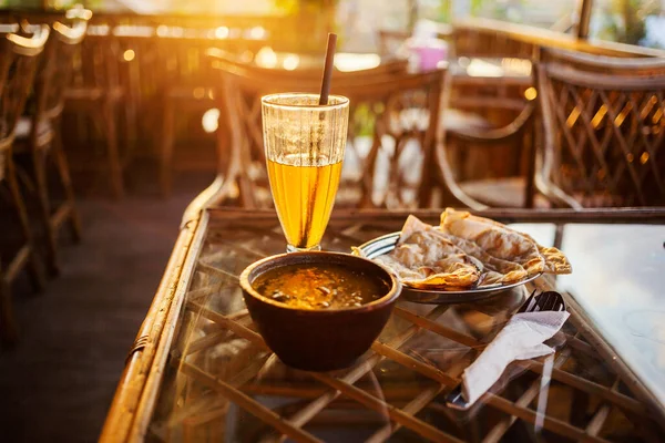 beer, curry, indian bread, cutlery, sunshine in a rural cafe in asia