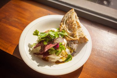 Lezzetli salata, yumurtalı Benedict ve tabakta ekmek kızartması. Yaz ışığında pencere eşiğinde mükemmel bir kahvaltı..