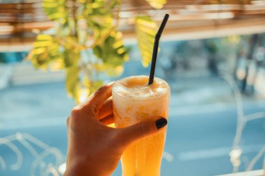 Buzlu lezzetli bir portakal kokteyli ve bir yaz barında pipet. Sıcak bir günde nefis bir içecek..