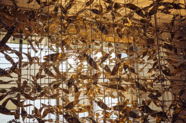 Yaratıcı iç kısımda parlayan çelikten yapılmış uçan kuşlarla dolu güzel bir metal iskelet. Lüks bir binanın tavanının altında modern dekorasyon..