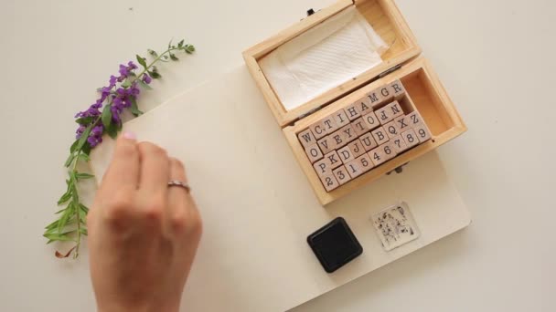 Girl writing Sports using stamp letters in journal for scrapbooking. — Stockvideo