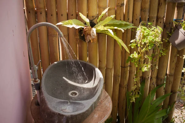 Заливаємо водопровідний кран, кам'яна раковина, літній сад — стокове фото
