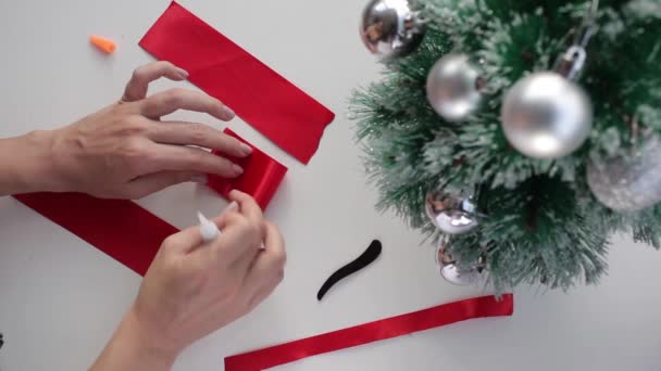 Время приготовления красного шелкового банта для рождественского декора — стоковое видео