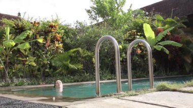 Havuzda yüzen ve dışarı çıkan bir kız. Yaz zamanı..