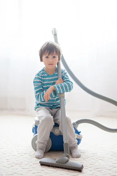 Dulce chico, jugando con aspiradora en casa — Foto de Stock