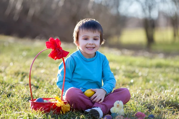 Αξιολάτρευτο παιδί στο πάρκο, διασκεδάζοντας με χρωματιστά αυγά για τιμίων — Φωτογραφία Αρχείου