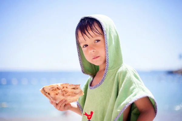 Słodkie małe dziecko, chłopiec, zielony ręcznik, jedzenie pizzy na b — Zdjęcie stockowe