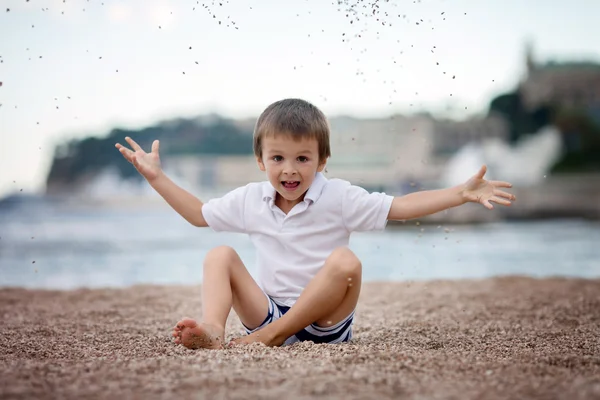 Dulce chico, jugando con la arena en la playa — Foto de Stock