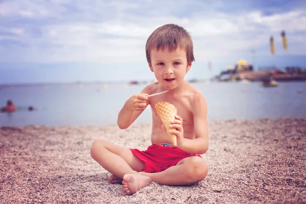 Doux petit enfant, garçon, manger de la glace sur la plage — Photo