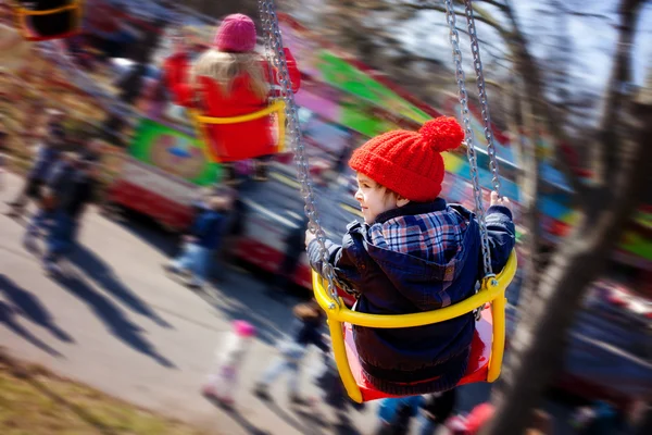 Gyerekek, szórakozás egy swing-lánc körhinta lovagolni — Stock Fotó