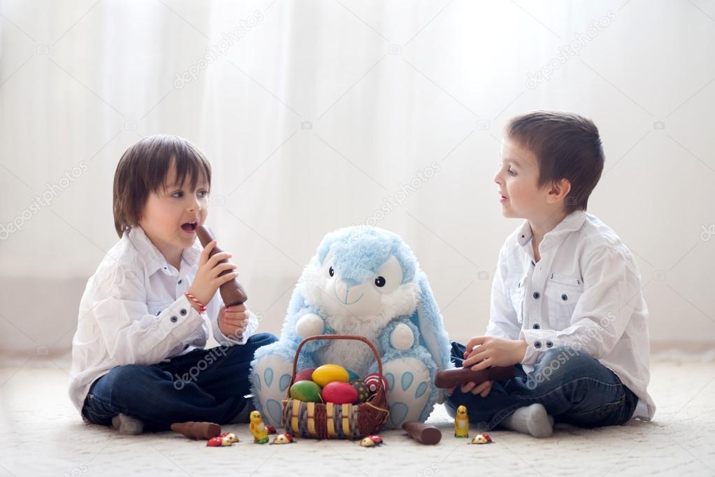 Two adorable little children, boy brothers, having fun eating ch