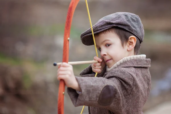 Menino pré-escolar adorável, atirar com arco e flecha no targe — Fotografia de Stock