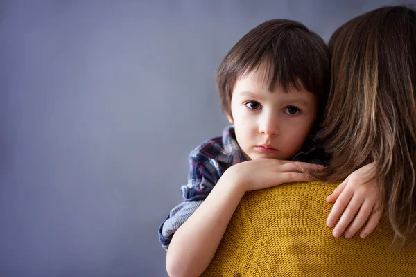 Beetje verdrietig kind, jongen, knuffelen zijn moeder thuis — Stockfoto