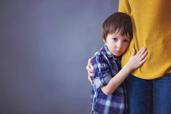 Sad little child, boy, hugging his mother at home — Stock Photo, Image