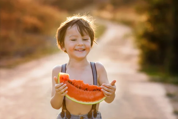 Krásné šťastné dítě, chlapec, jíst velké dílek melounu — Stock fotografie