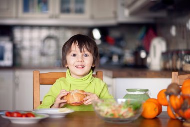 Güzel bir çocuk, evde sandviç yemek