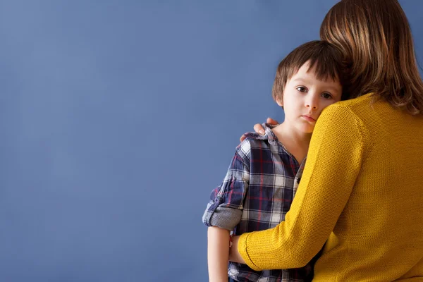 Criança triste, menino, abraçando sua mãe em casa — Fotografia de Stock